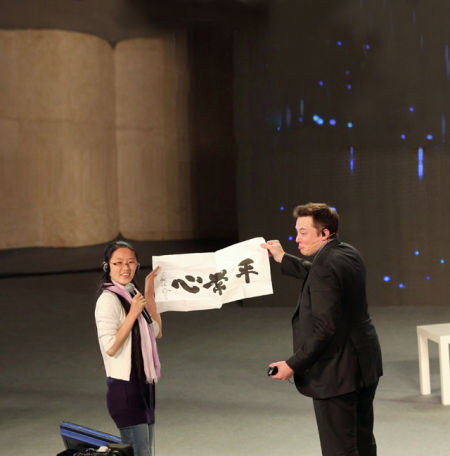 　4 月21 日，北京，埃隆·馬斯克站在極客公園“奇點(diǎn)大會”的舞臺上。他穿著正統(tǒng)的黑色西裝，參與錄制央視《對話》節(jié)目。節(jié)目錄制完成，一位女粉絲沖上臺，送給埃隆·馬斯克一幅書法大師寫的字：“平常心”
