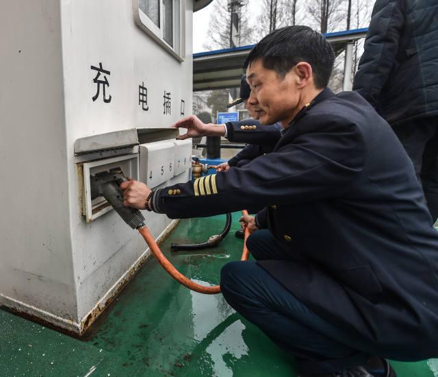 1月18日，工作人員在為純電動貨運船插上充電線。該電動貨運船一次充電可以行駛200至300公里，充電時間大約6至8小時。